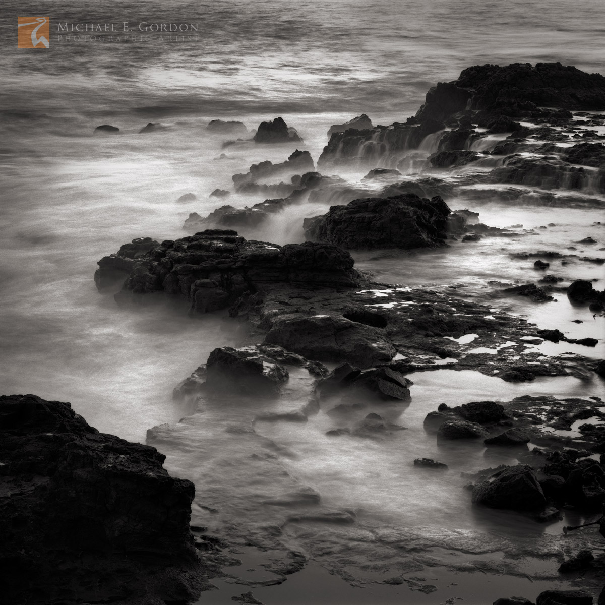 A long exposure reveals a misty and ethereal rocky coastline.Logos and watermarks are not found on any printed product. This...