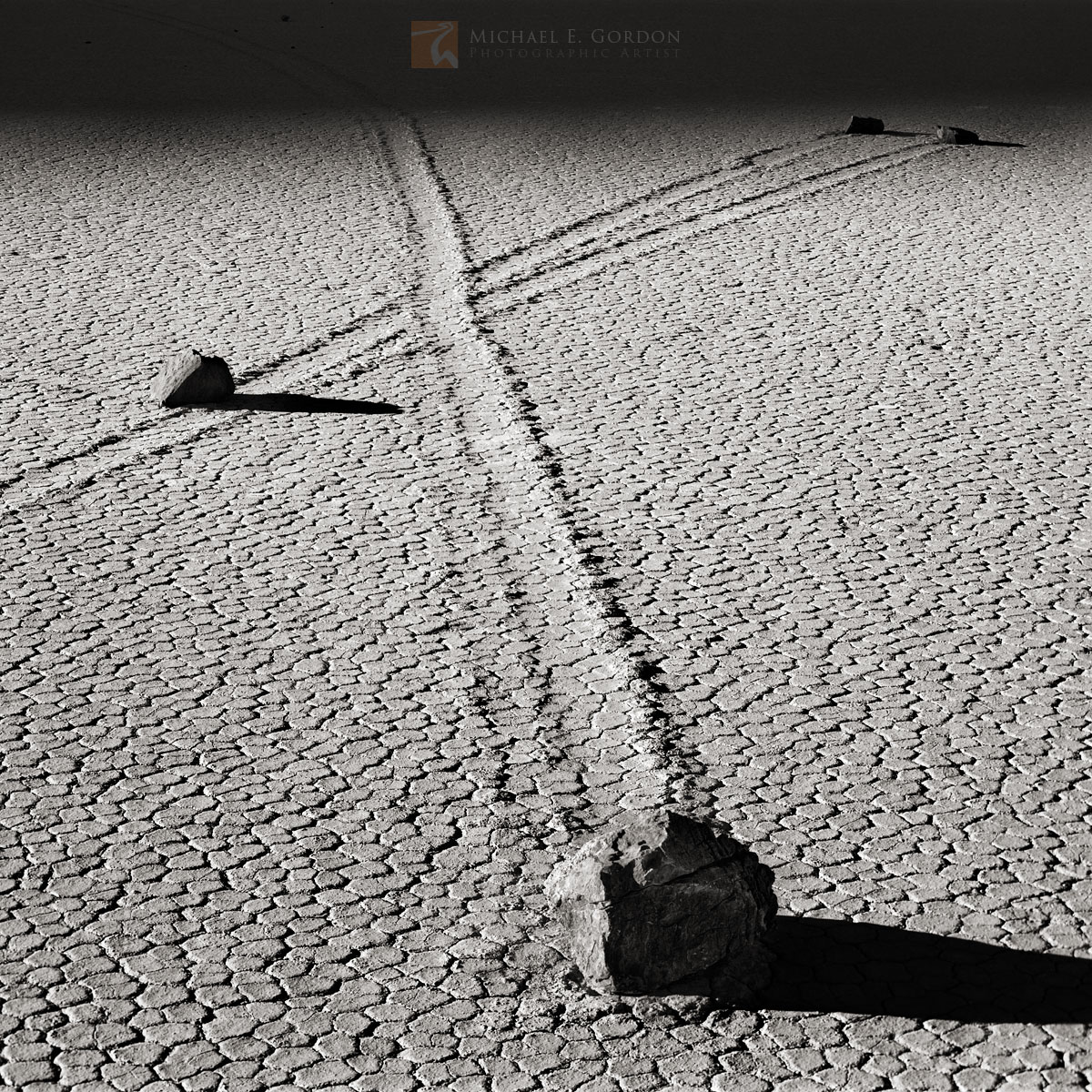 Shadows creep across the mysterious and unique calligraphic tracks left by&nbsp;sliding stones on The Racetrack.Logos and watermarks...