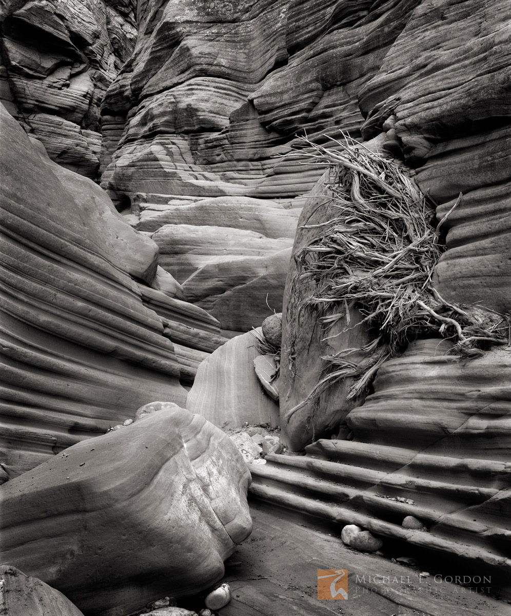 Flash flood debris packed into the narrow sandstone grooves and boulders of a slot canyon.&nbsp;Logos and watermarks are not...