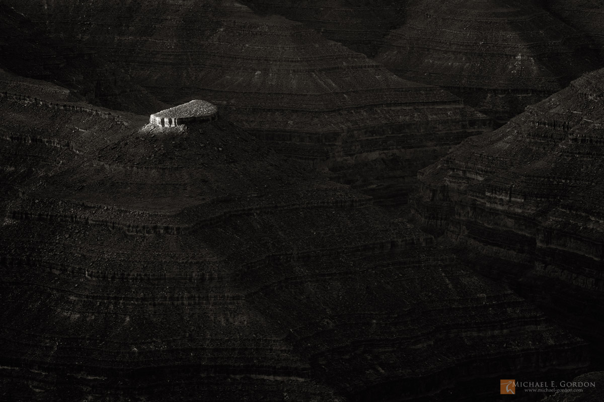 The first light of the day strikes the top of a mesa above San Juan River. Glen Canyon National Recreation Area, Utah.