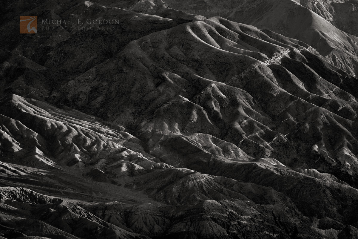 Light and long shadows fall on the the eroded&nbsp;creases and canyons of&nbsp;the&nbsp;Black Mountains.Logos and watermarks...